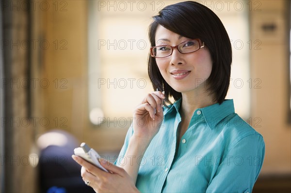 Asian woman smiling with electronic organizer