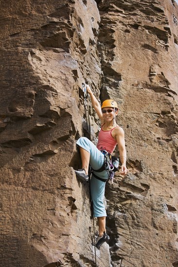 Asian woman rock climbing