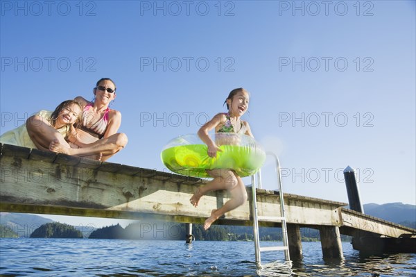 Asian girl jumping in lake