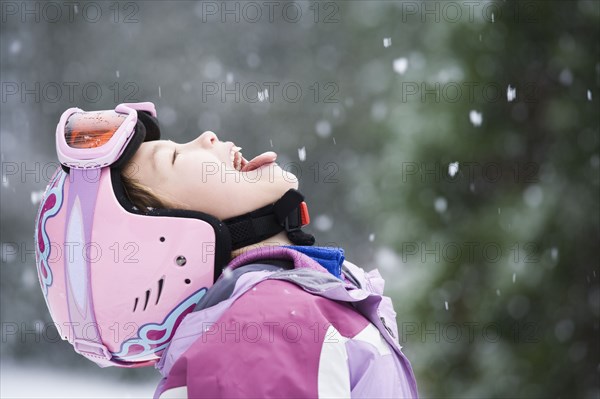 Asian girl sticking out tongue in snow