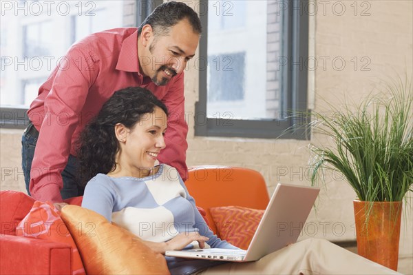 Hispanic couple looking at laptop