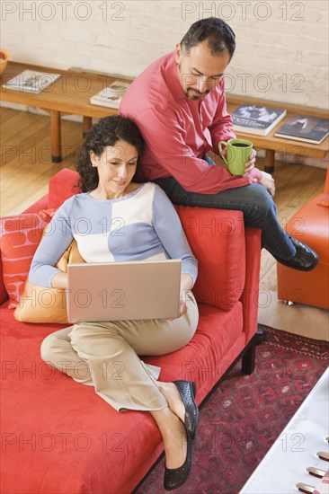 Hispanic couple looking at laptop