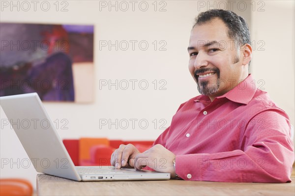 Hispanic man typing on laptop