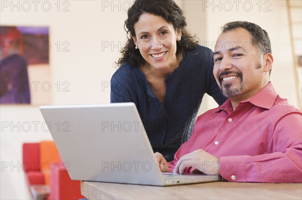 Hispanic couple next to laptop