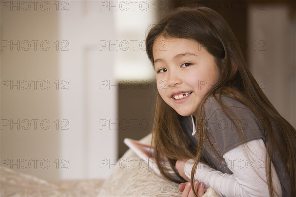 Mixed race girl smiling on sofa