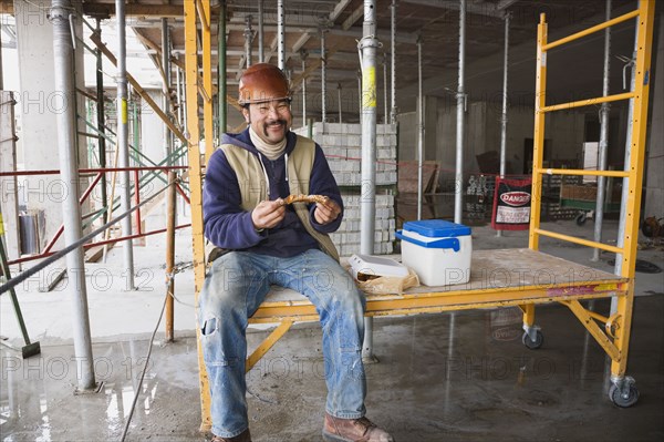 Mixed race construction worker eating lunch