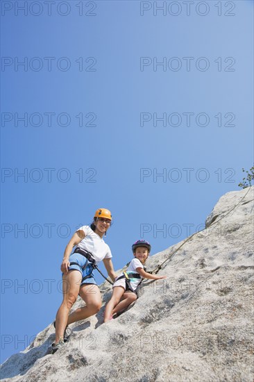 Asian mother and daughter rock climbing