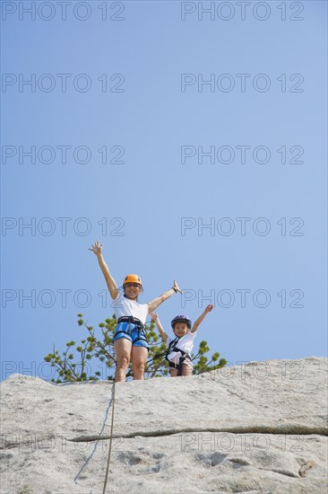 Asian mother and daughter rock climbing