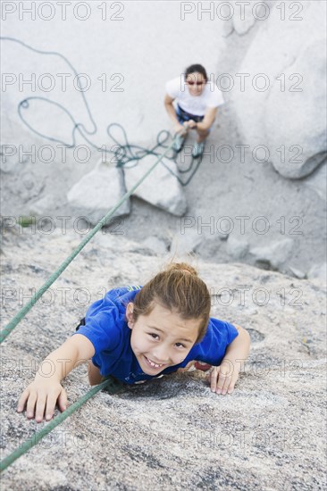 Asian mother and daughter rock climbing