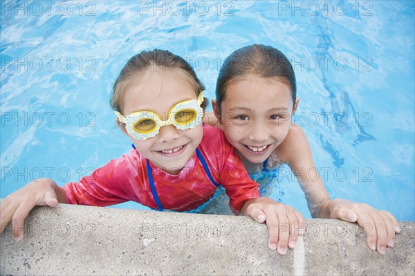 Asian sisters swimming in pool