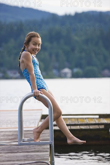 Asian girl jumping off dock