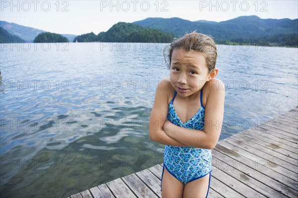 Cold Asian girl standing on dock