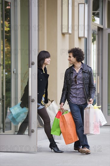 Couple leaving store with shopping bags