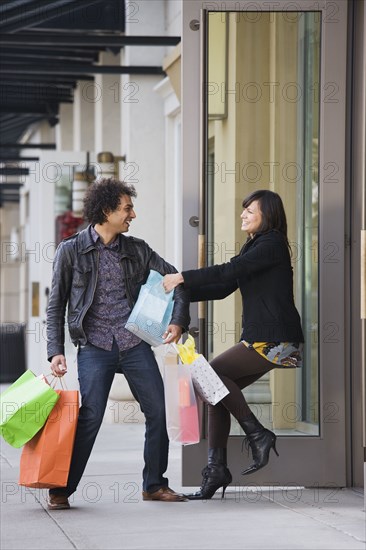 Woman pulling boyfriend into store