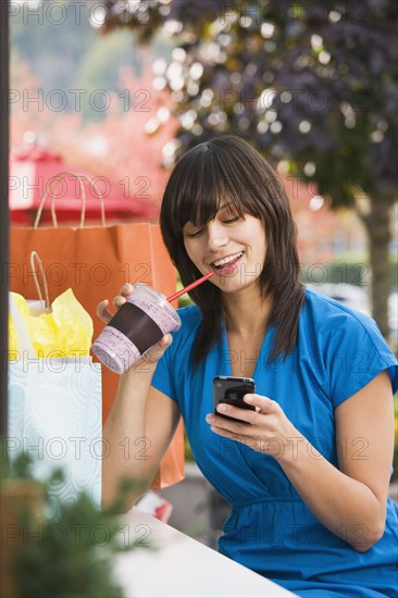 Mixed race woman text messaging on cell phone