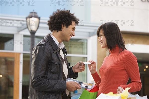 Middle Eastern man giving girlfriend credit card