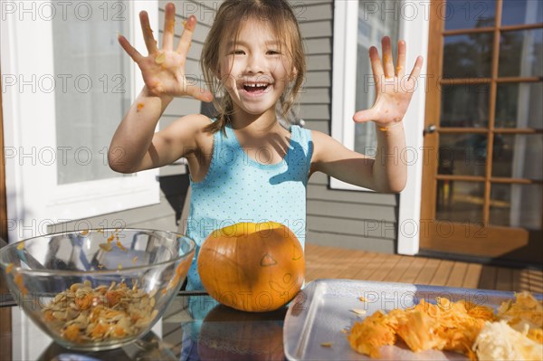 Mixed race young girl preparing Halloween pumpkin