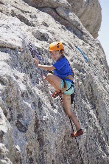 Mixed race girl rock climbing