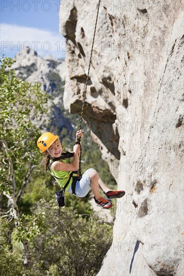 Mixed race girl rock climbing