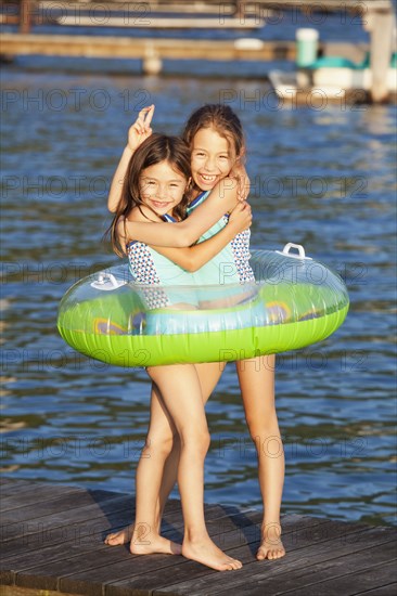 Mixed race sisters playing on pier