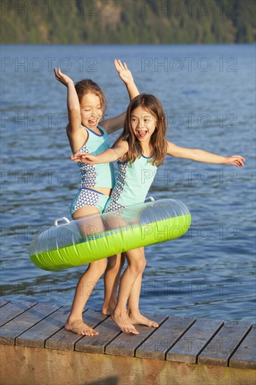 Mixed race sisters playing on pier