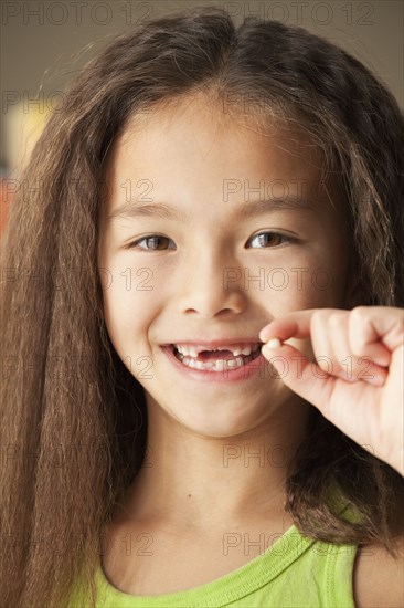 Mixed race girl holding toothy