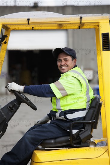 Hispanic man driving forklift