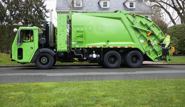 Garbage men operating garbage truck