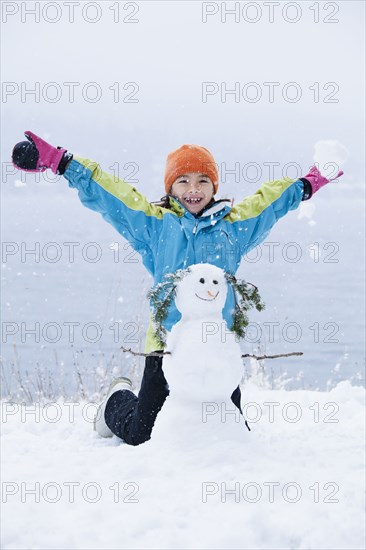Mixed race girl building snowman