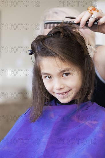 Mixed race girl getting her hair cut