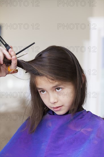 Mixed race girl getting her hair cut