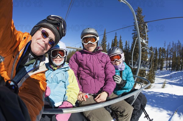 Family riding ski lift together