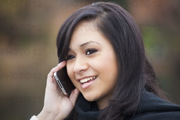 Hispanic teenage girl talking on cell phone