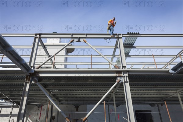 Caucasian construction worker standing on girder