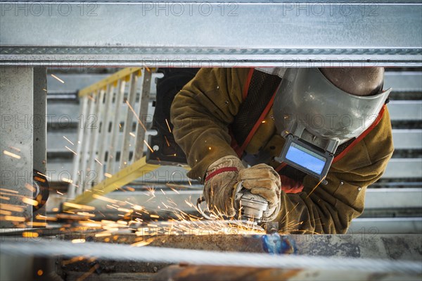 Construction worker grinding metal
