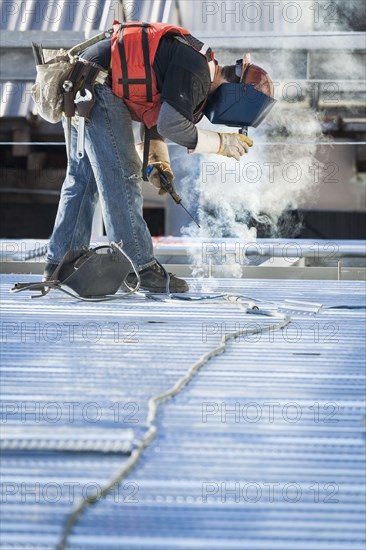 Caucasian construction worker welding floor