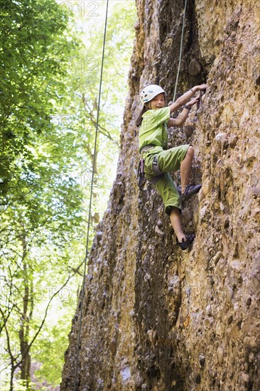 Mixed race girl rock climbing