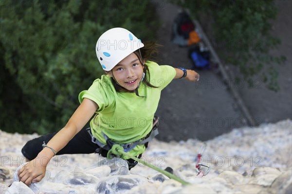 Mixed race girl rock climbing