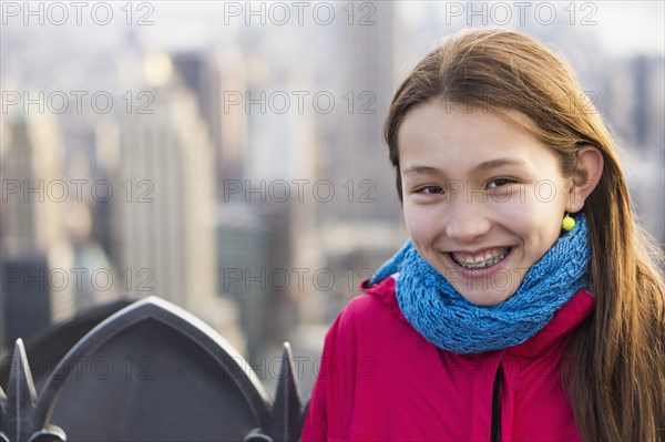 Mixed race girl smiling on urban rooftop