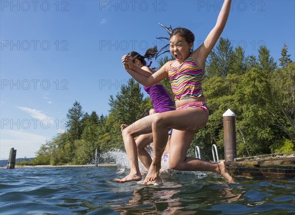 Girls jumping together into lake