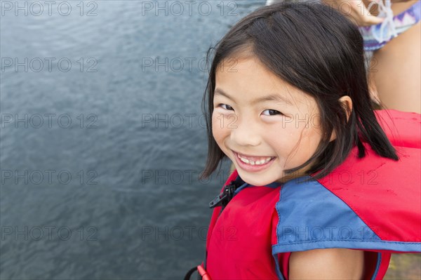 Mixed race girl smiling by lake