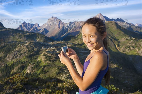 Mixed race girl photographing mountains