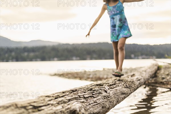 Mixed race girl walking on log