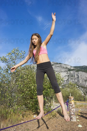 Mixed race girl walking on tightrope