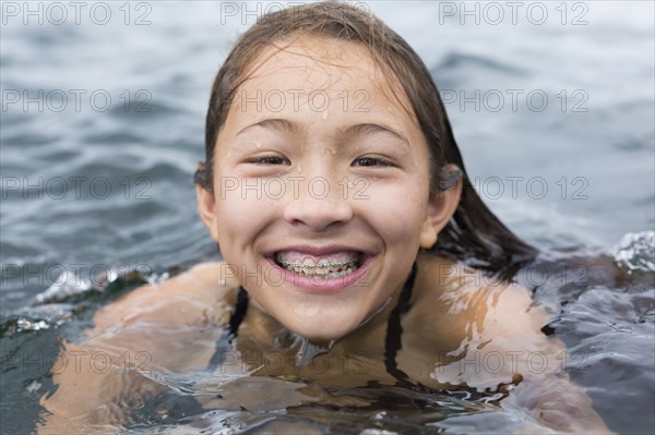 Mixed race girl swimming outdoors