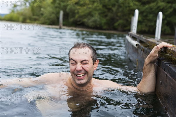 Caucasian man swimming in lake