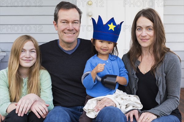 Family smiling together outside house