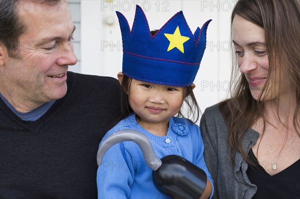 Parents holding daughter with hook and crown