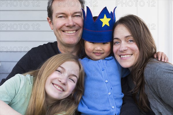 Family smiling together outside house