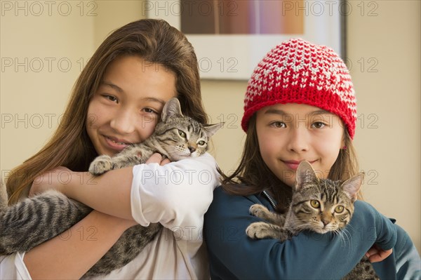 Mixed race girls holding kittens